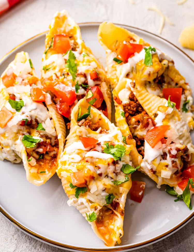 White plate with taco stuffed shells and toppings