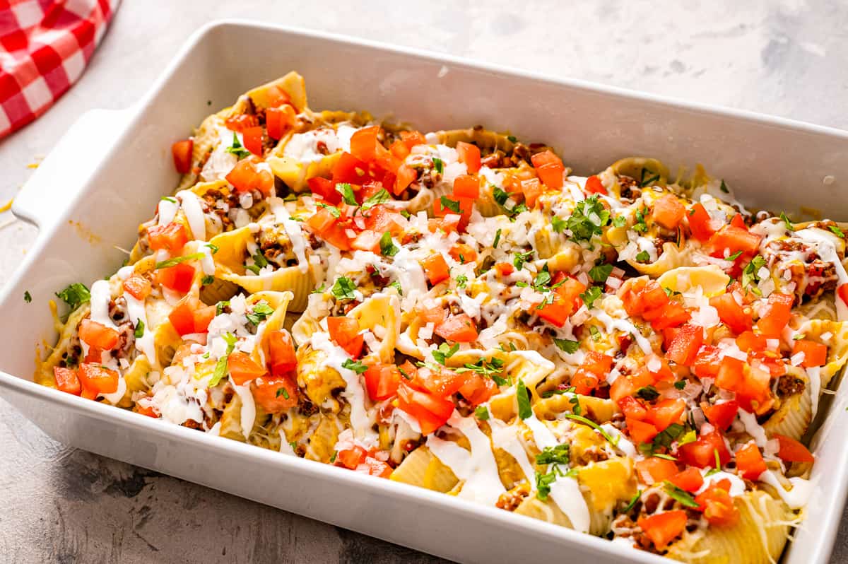 White casserole dish with cheesy taco stuffed shells