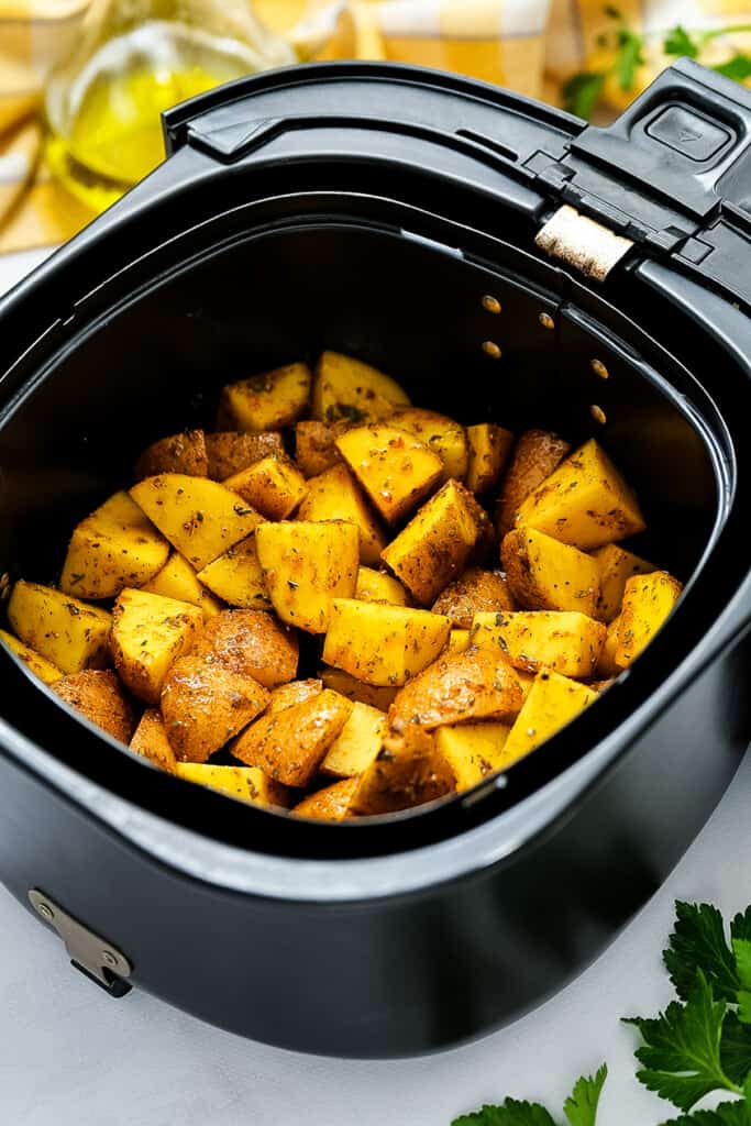 Air Fryer basket with diced potatoes before cooking