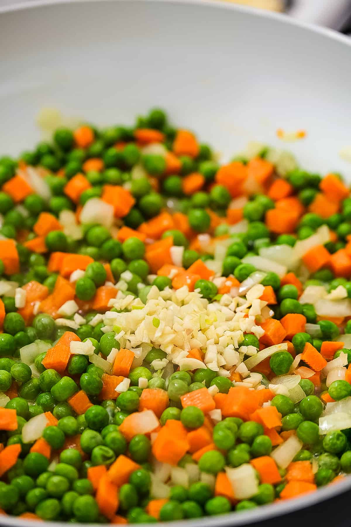 Skillet with peas, carrots, onions and garlic