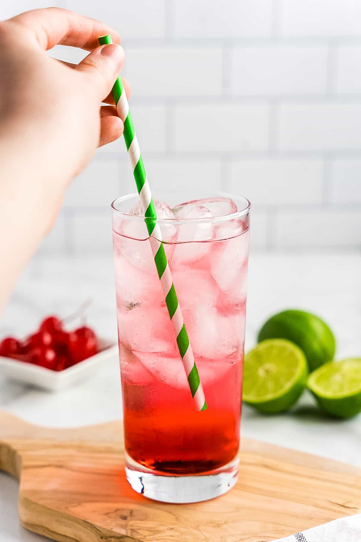 Stirring cocktail with paper straw
