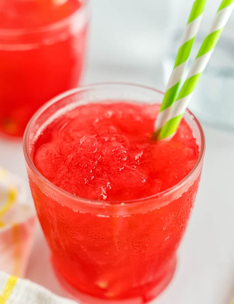 Rhubarb Slush in glass with green paper straw.