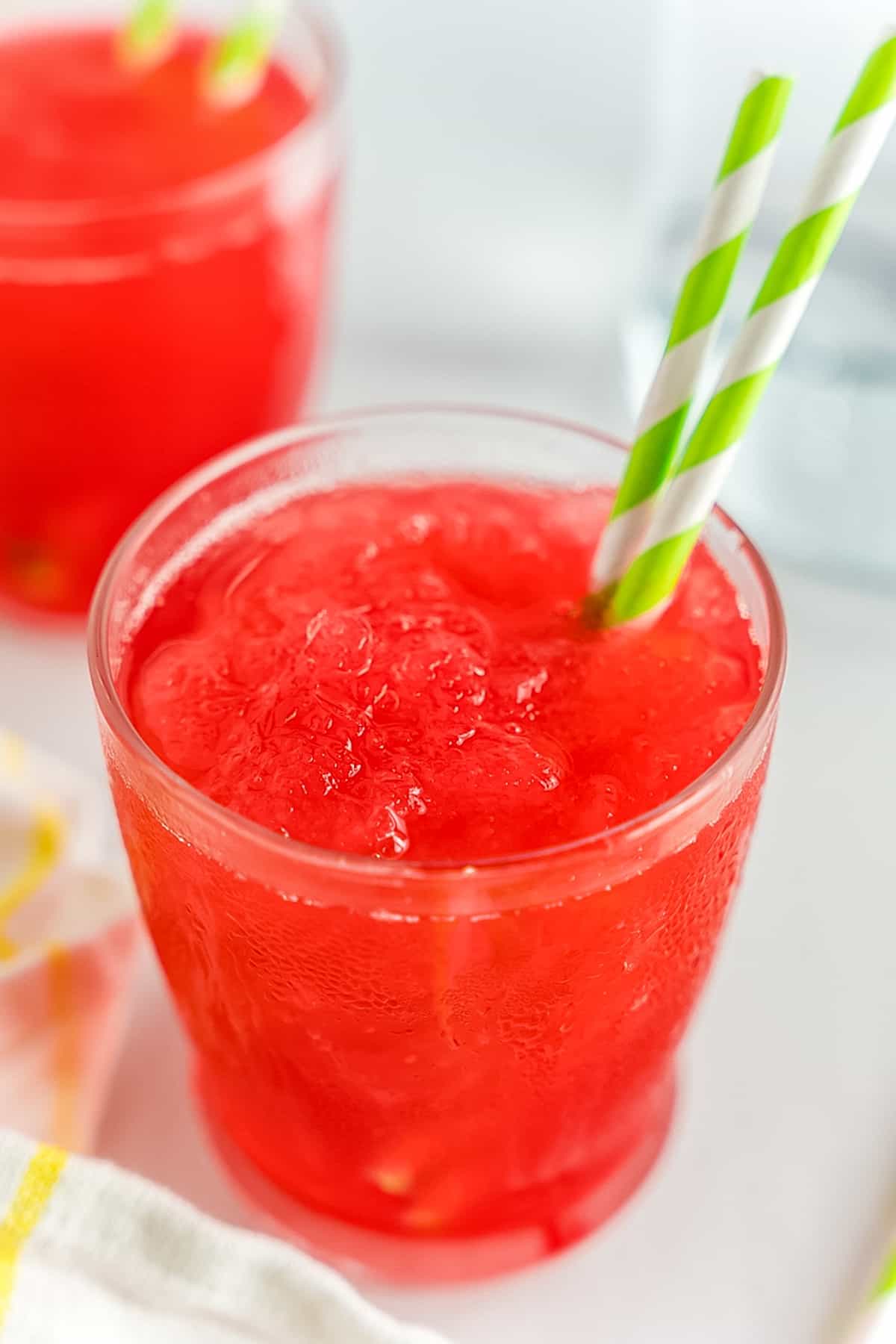 Rhubarb  Slush in glass with green paper straw.