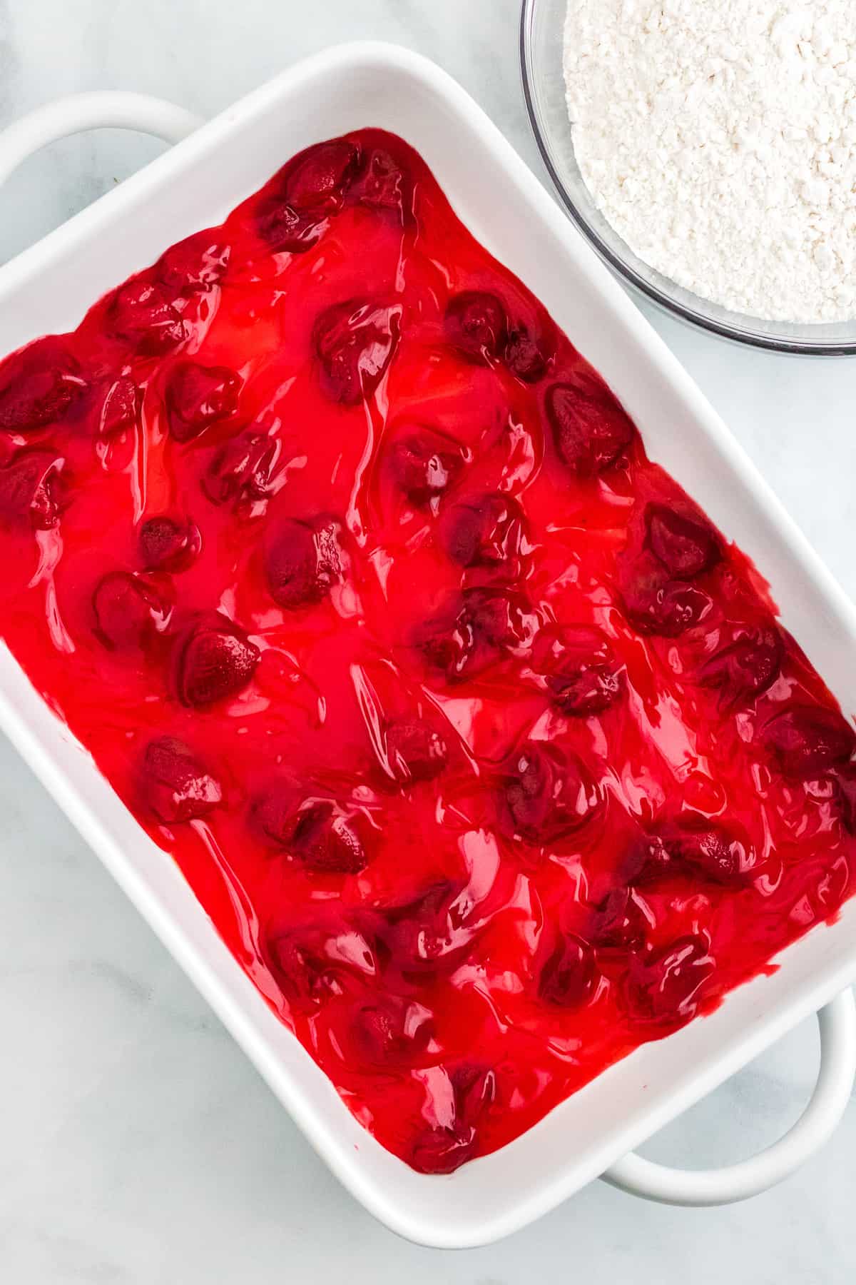 white baking dish with strawberry pie filling