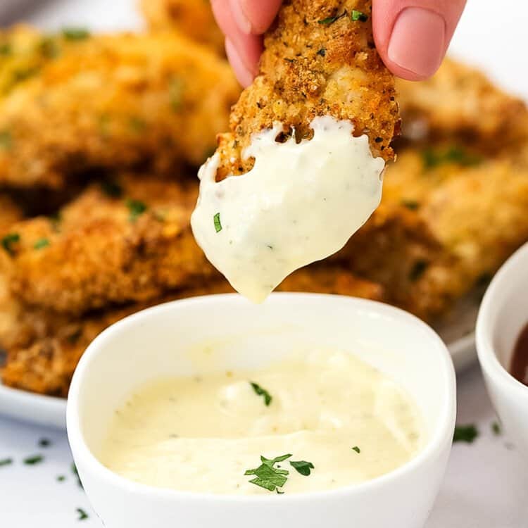 Air Fryer Chicken Strips being dipped into ranch