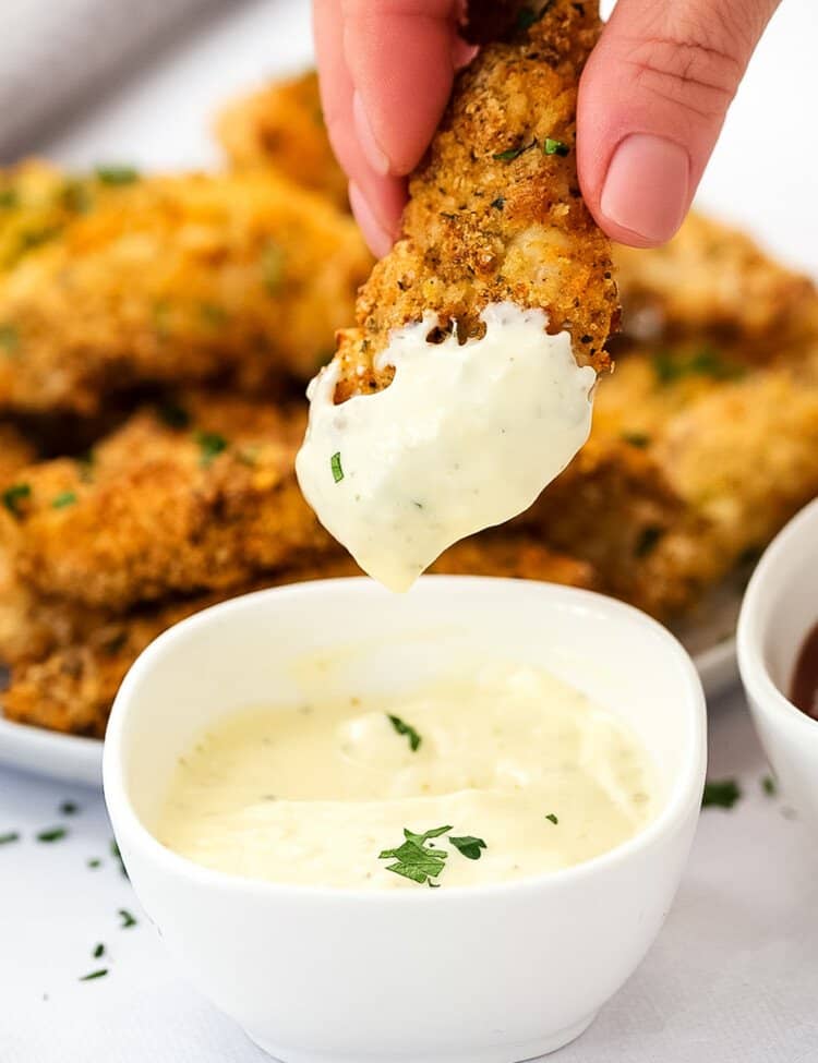 Air Fryer Chicken Strips being dipped into ranch