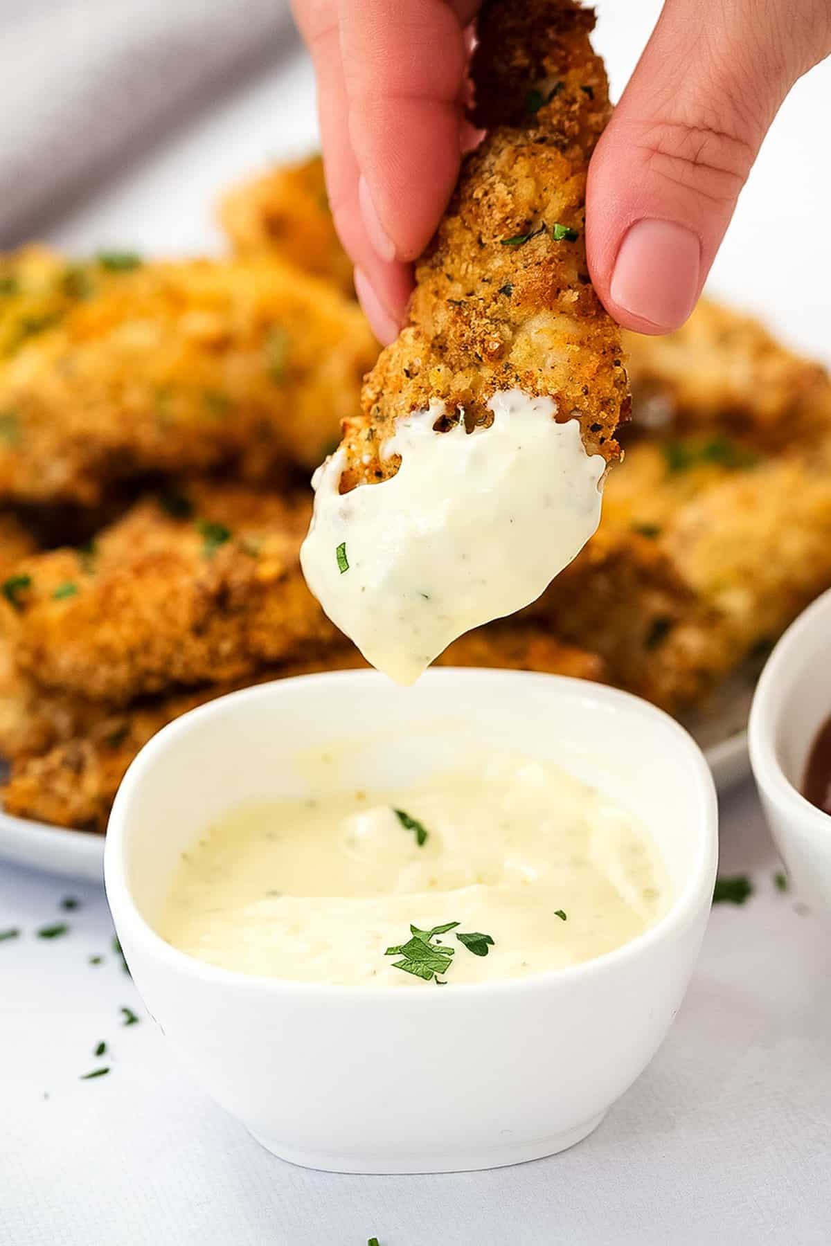Air Fryer Chicken Strips being dipped into ranch