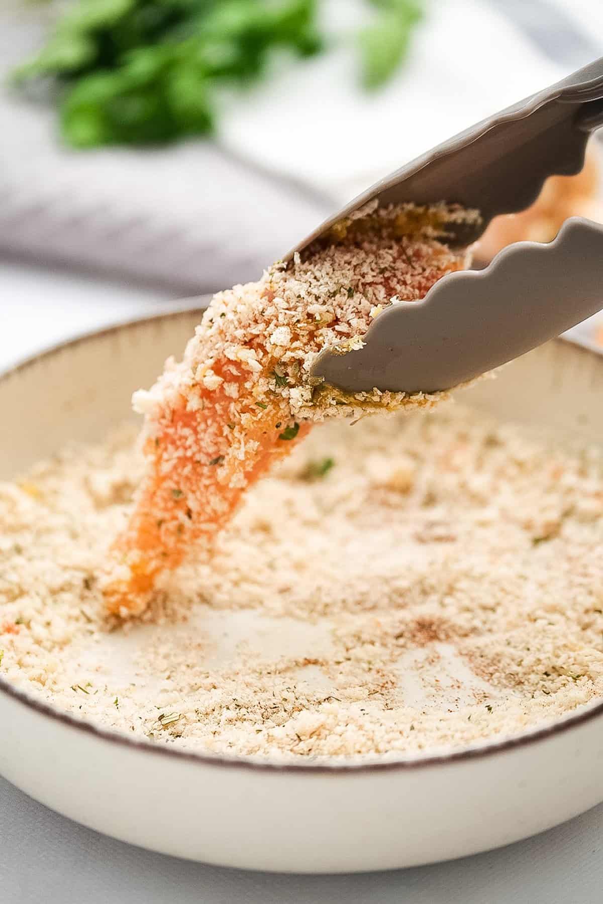 Dipping chicken strip in breading