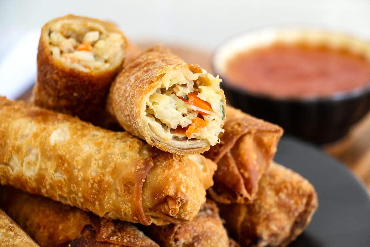 Stack of egg rolls with one cut open