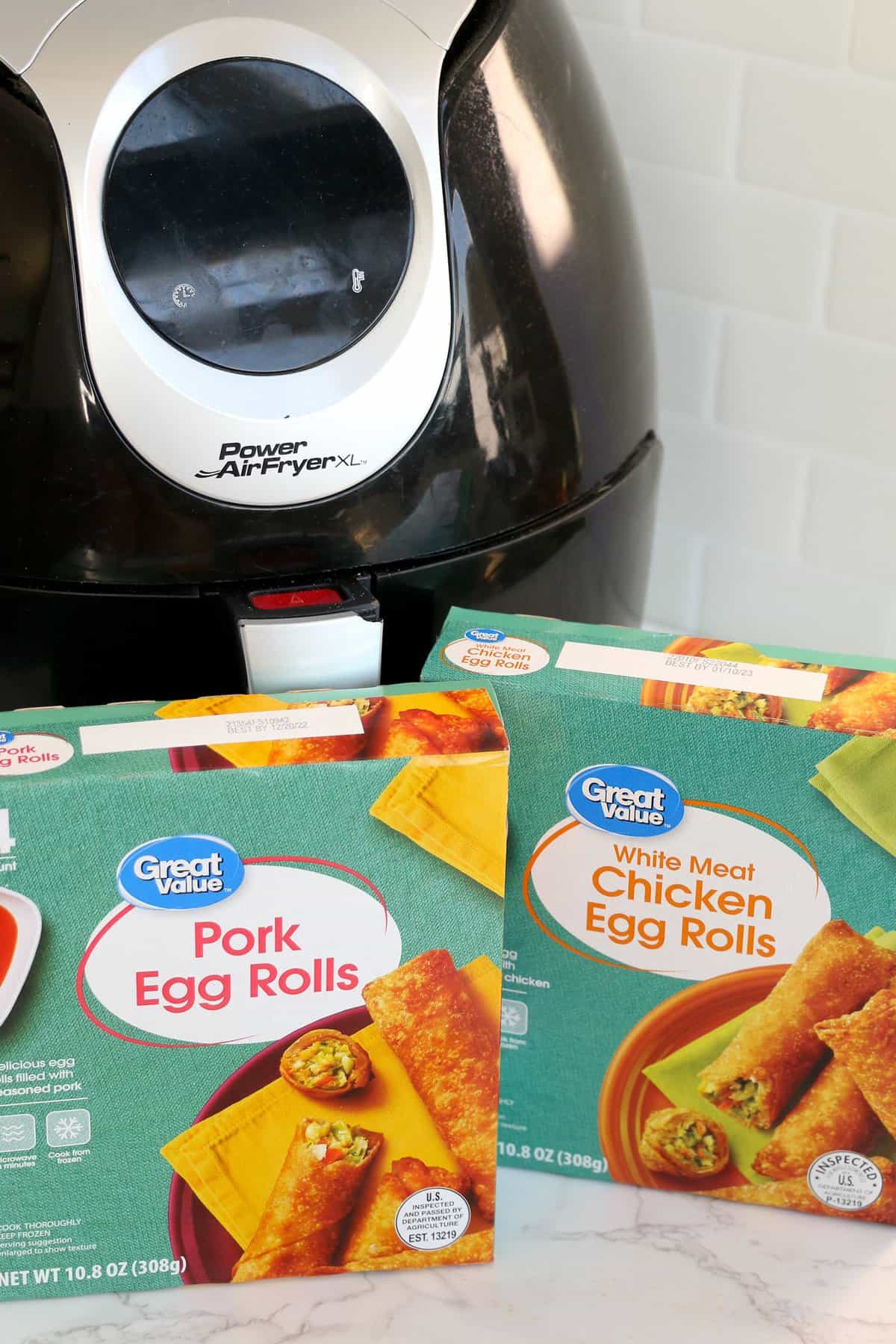 Two boxes of egg rolls and an air fryer in background