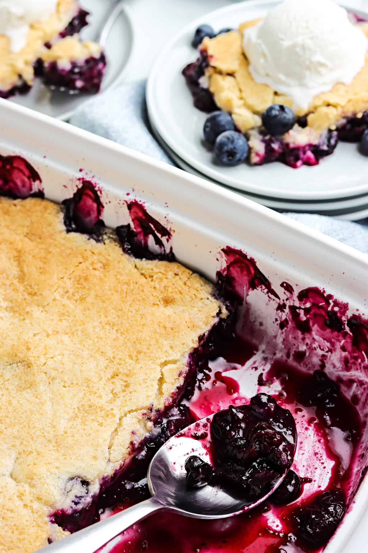 Pan of blueberry cobbler with some gone.