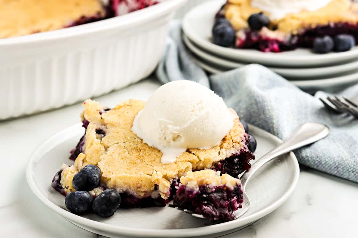 white plate with blueberry cobbler on it.