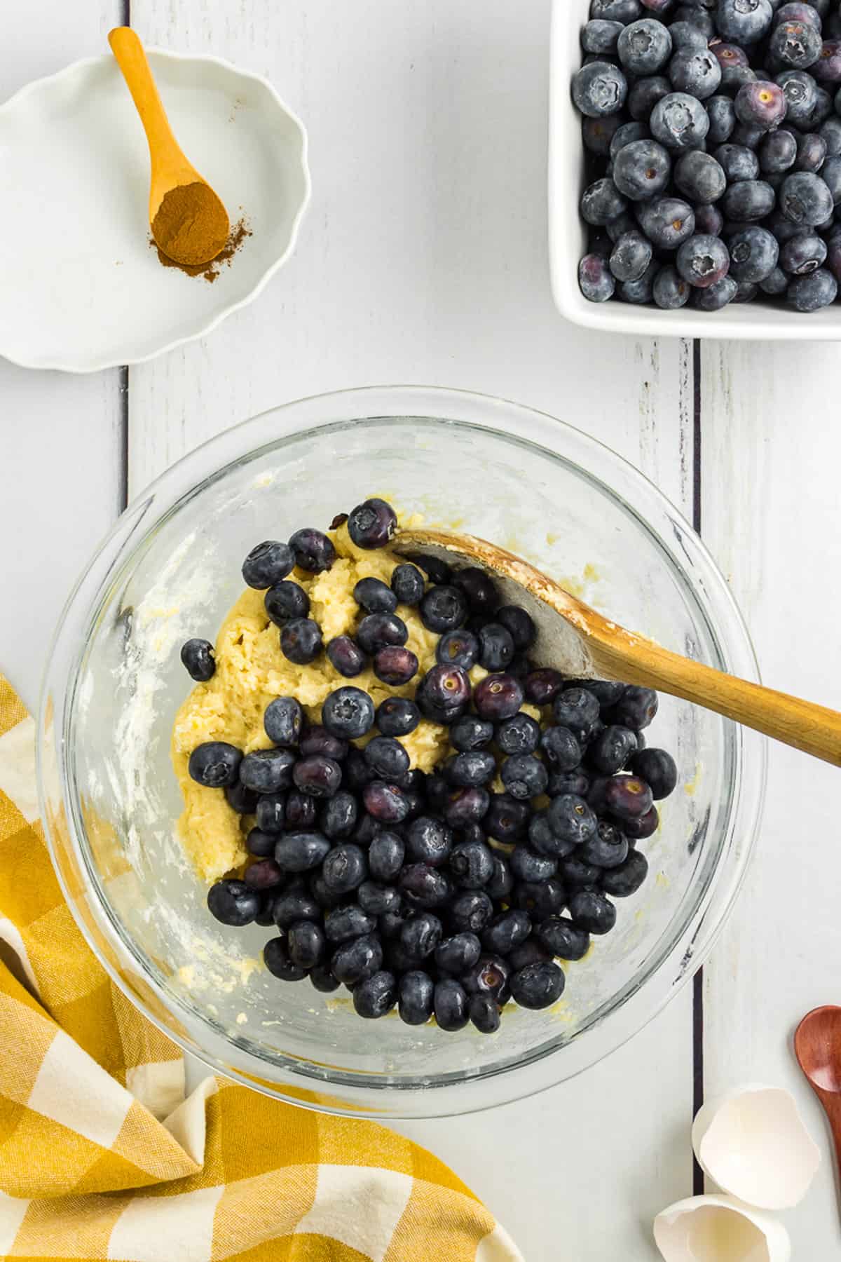 Folding blueberries into a bowl of batter