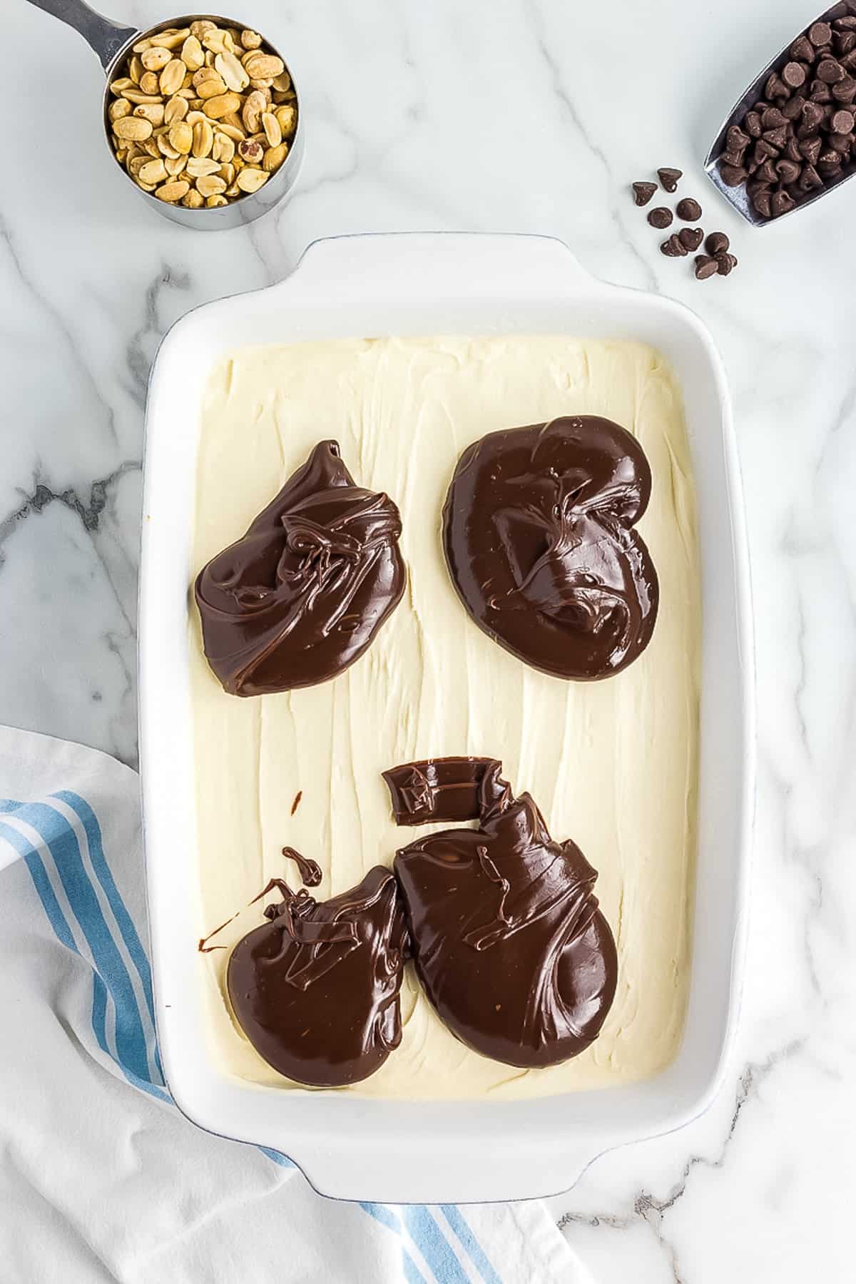 White casserole dish with scoops of fudge sauce on vanilla ice cream