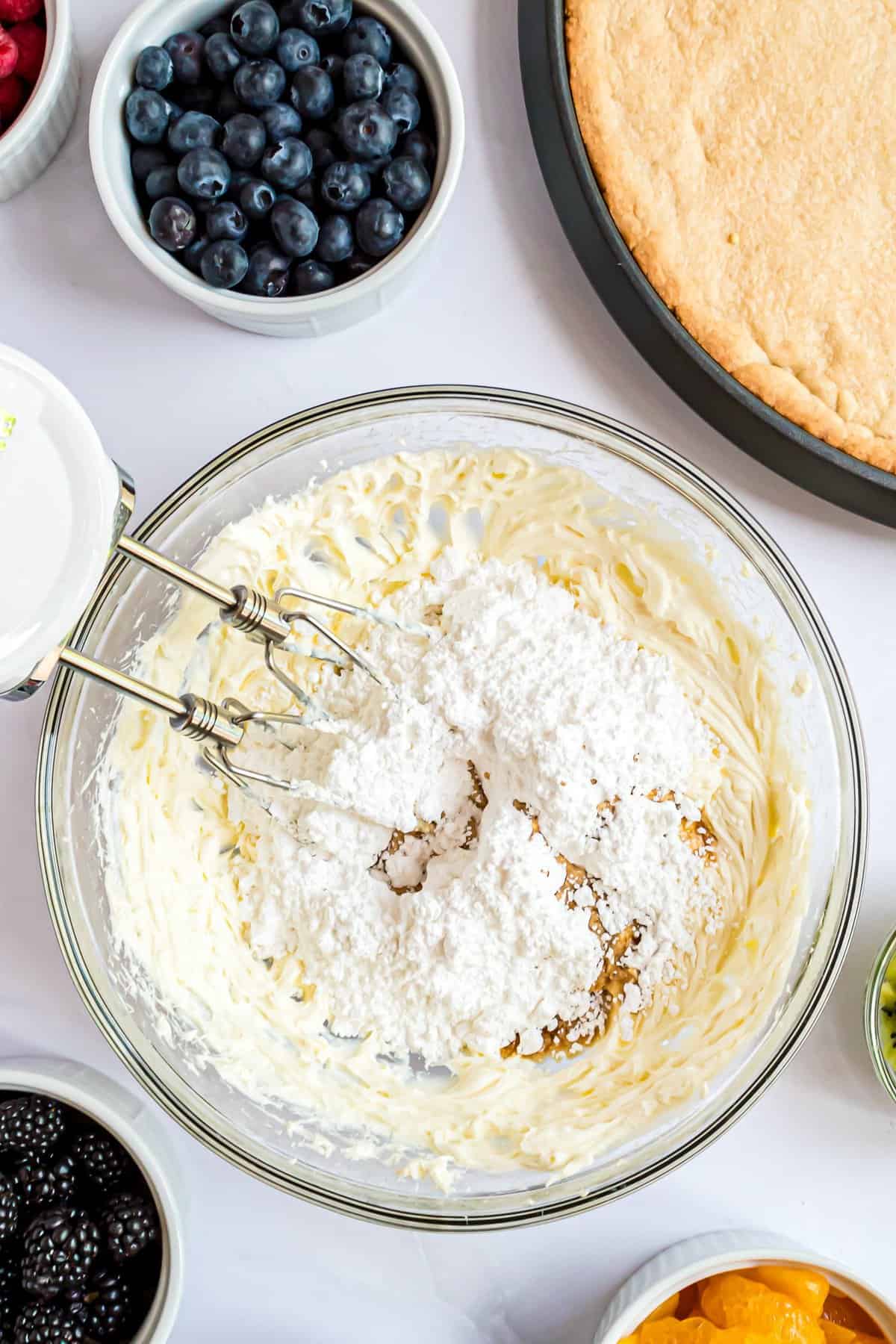 adding powdered sugar to frosting