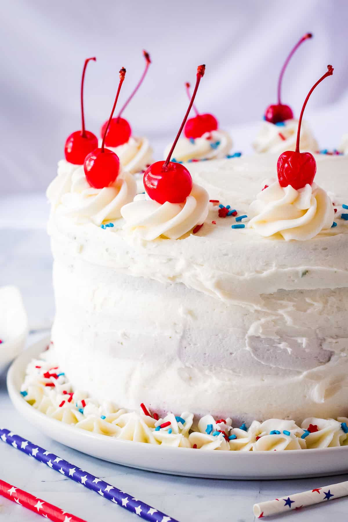Two tiered cake with cherries, patriotic sprinkles and cherries
