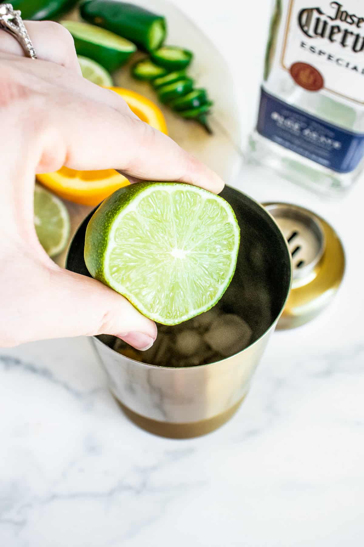 Squeezing lime juice into cocktail shaker