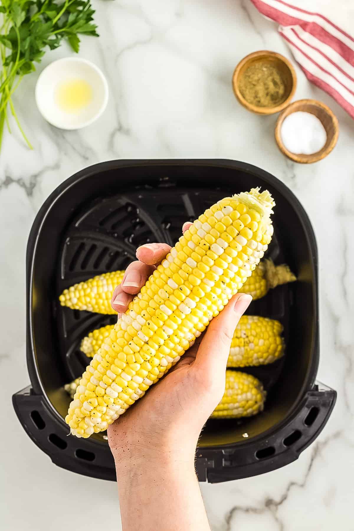 Hand holding cob of corn