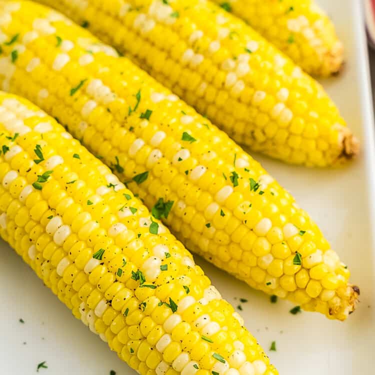 Four pieces of corn on white platter
