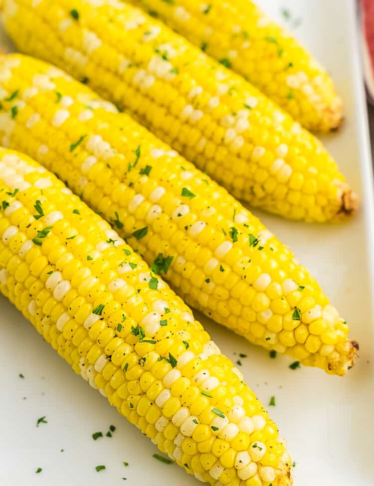 Four pieces of corn on white platter