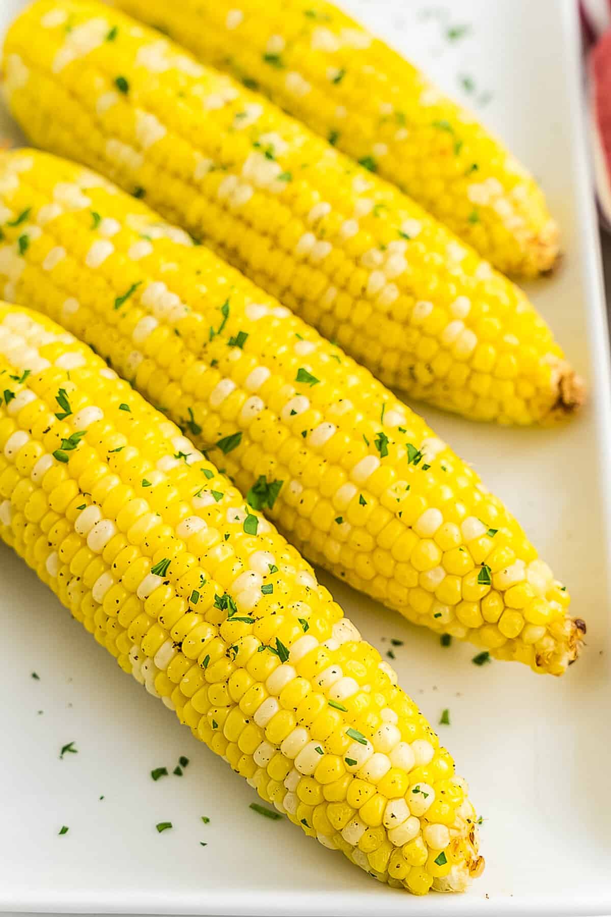 Four pieces of corn on white platter