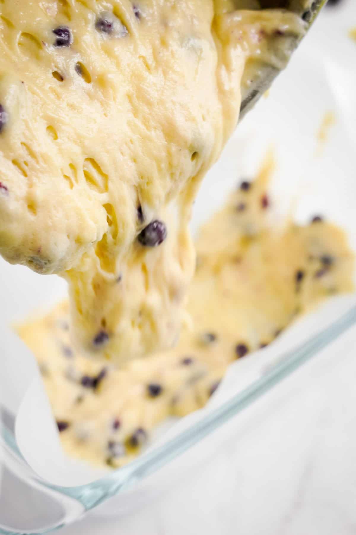 Pouring blueberry bread batter into pan