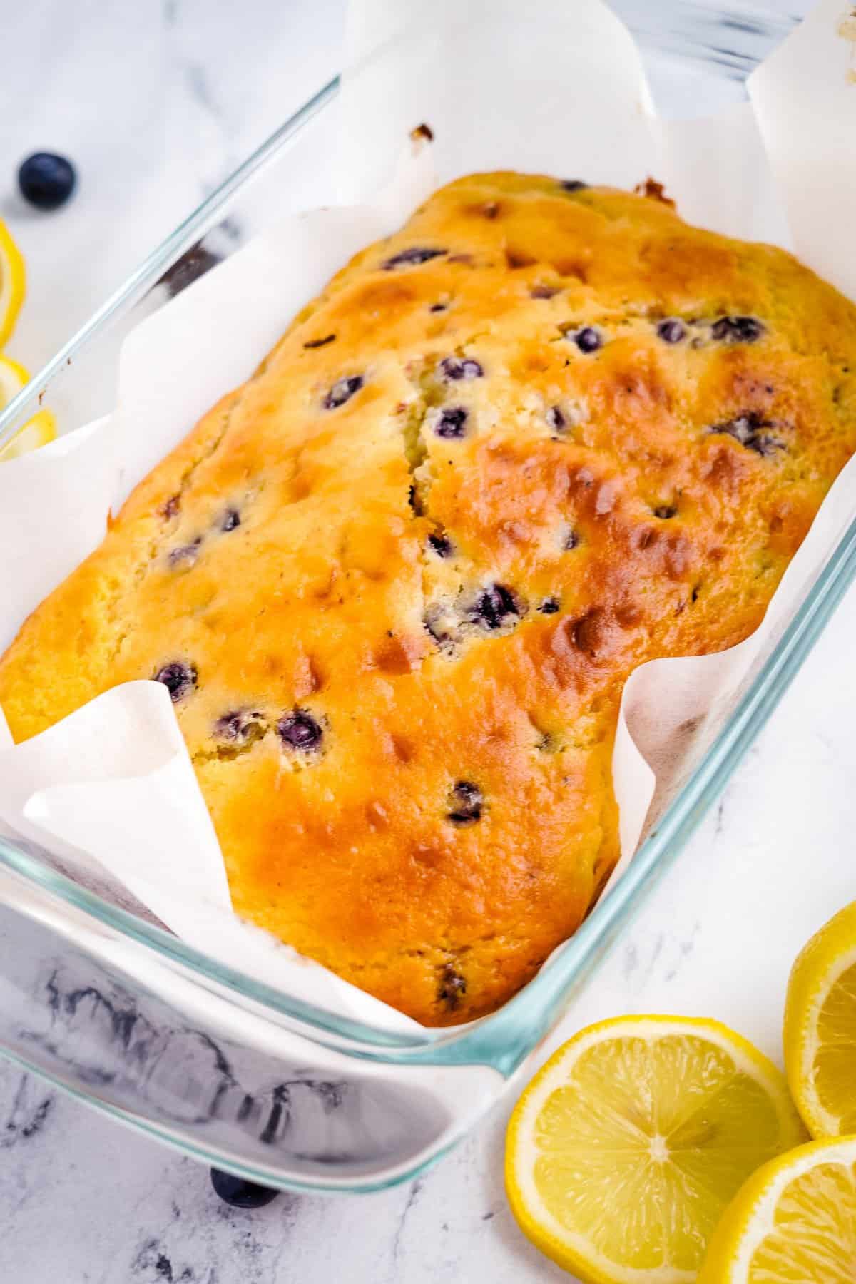 Loaf of baked lemon blueberry bread in pan