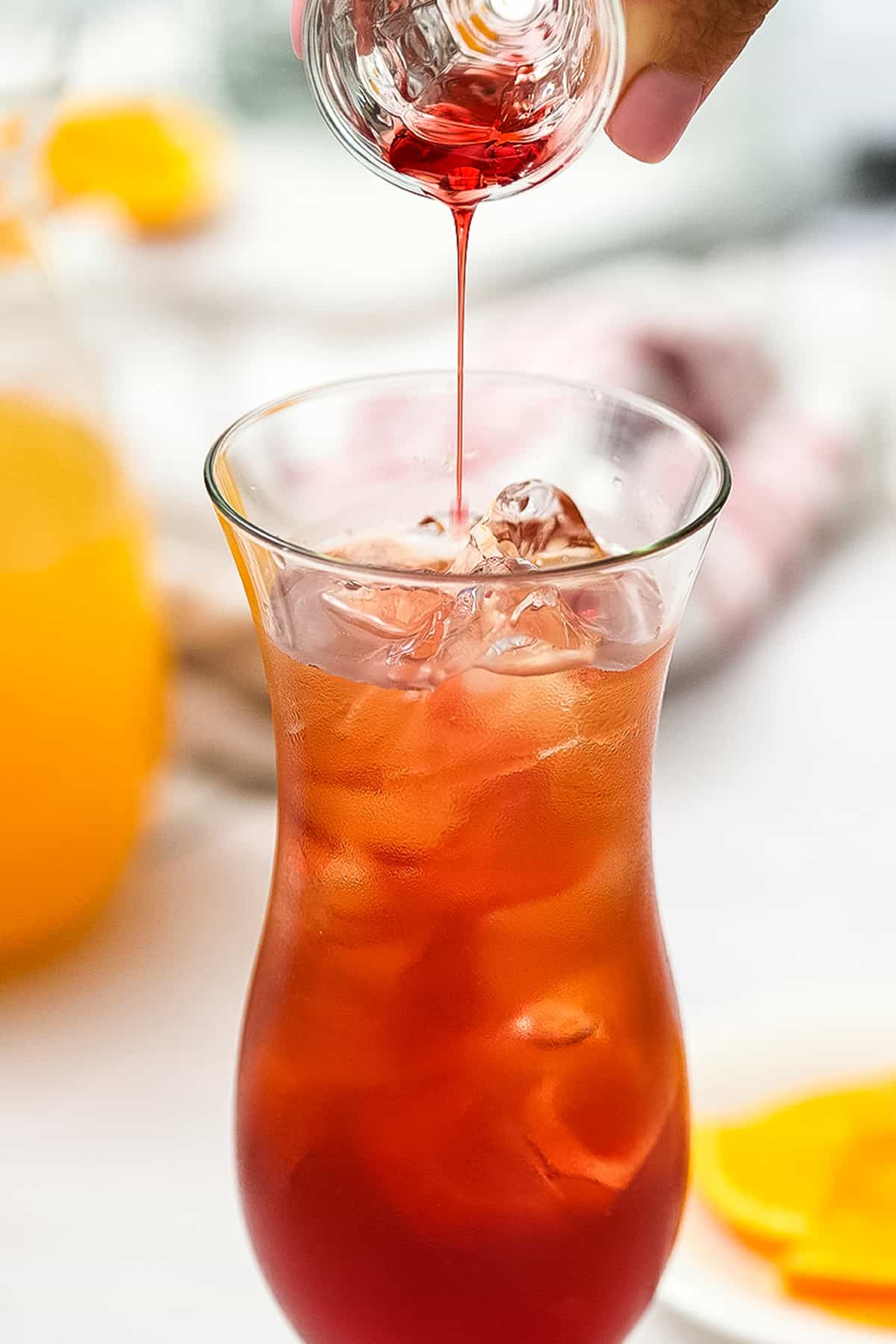 Pouring grenadine into cocktail