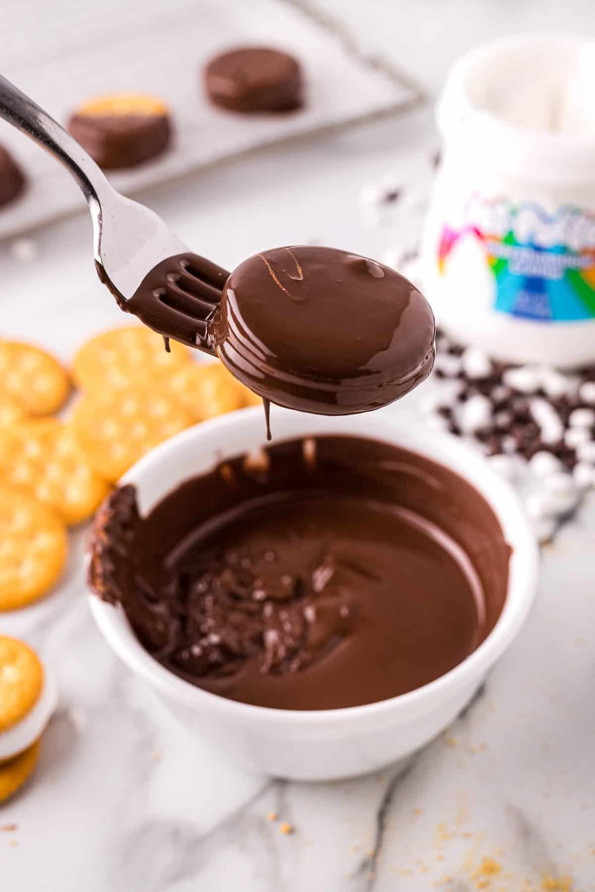 Forking dipping ritz cracker cookies in chocolate