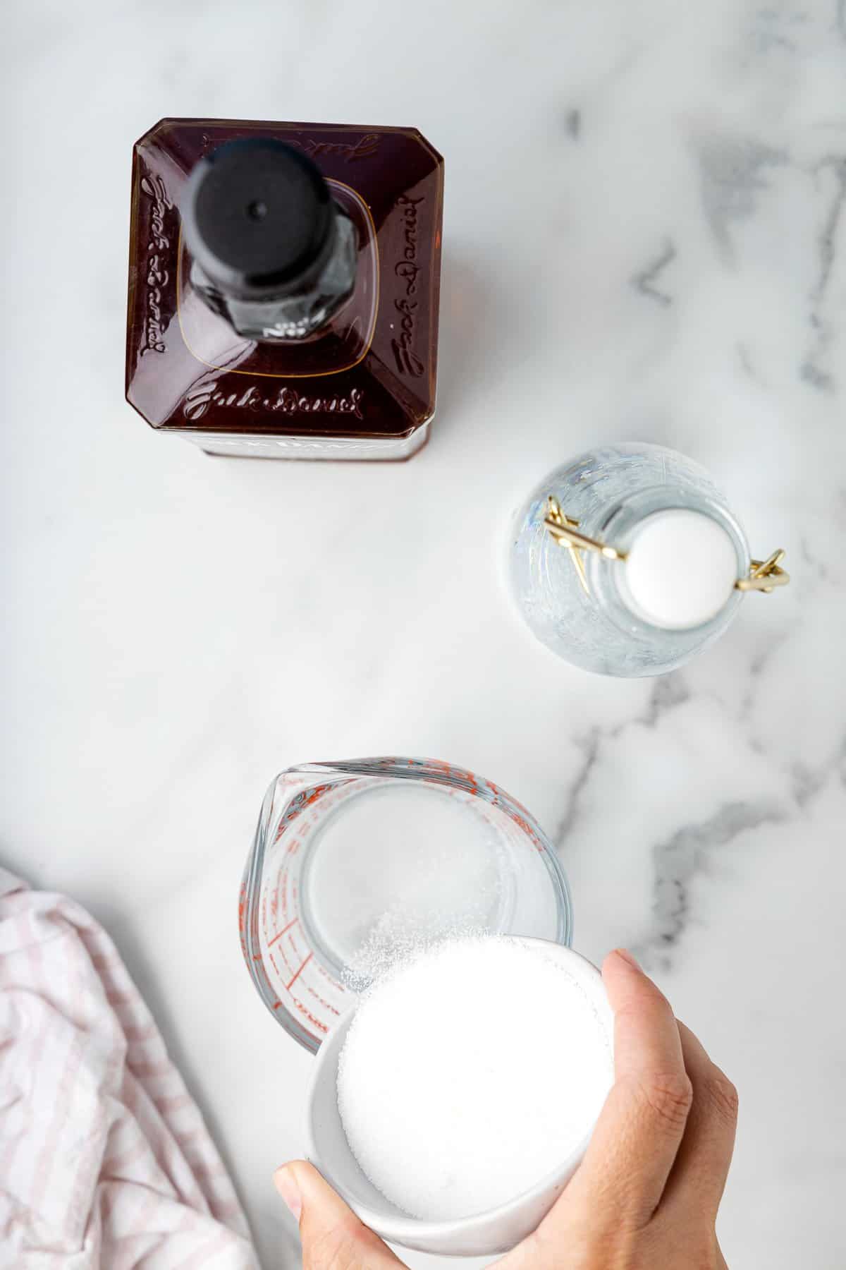 Pouring sugar into glass measuring cup