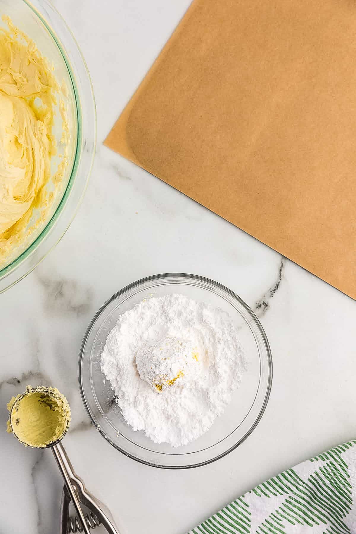 Rolling a cookie in powdered sugar