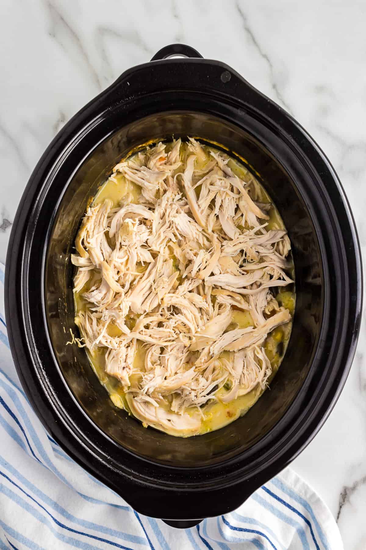 Shredded chicken in crock pot with pot pie ingredients