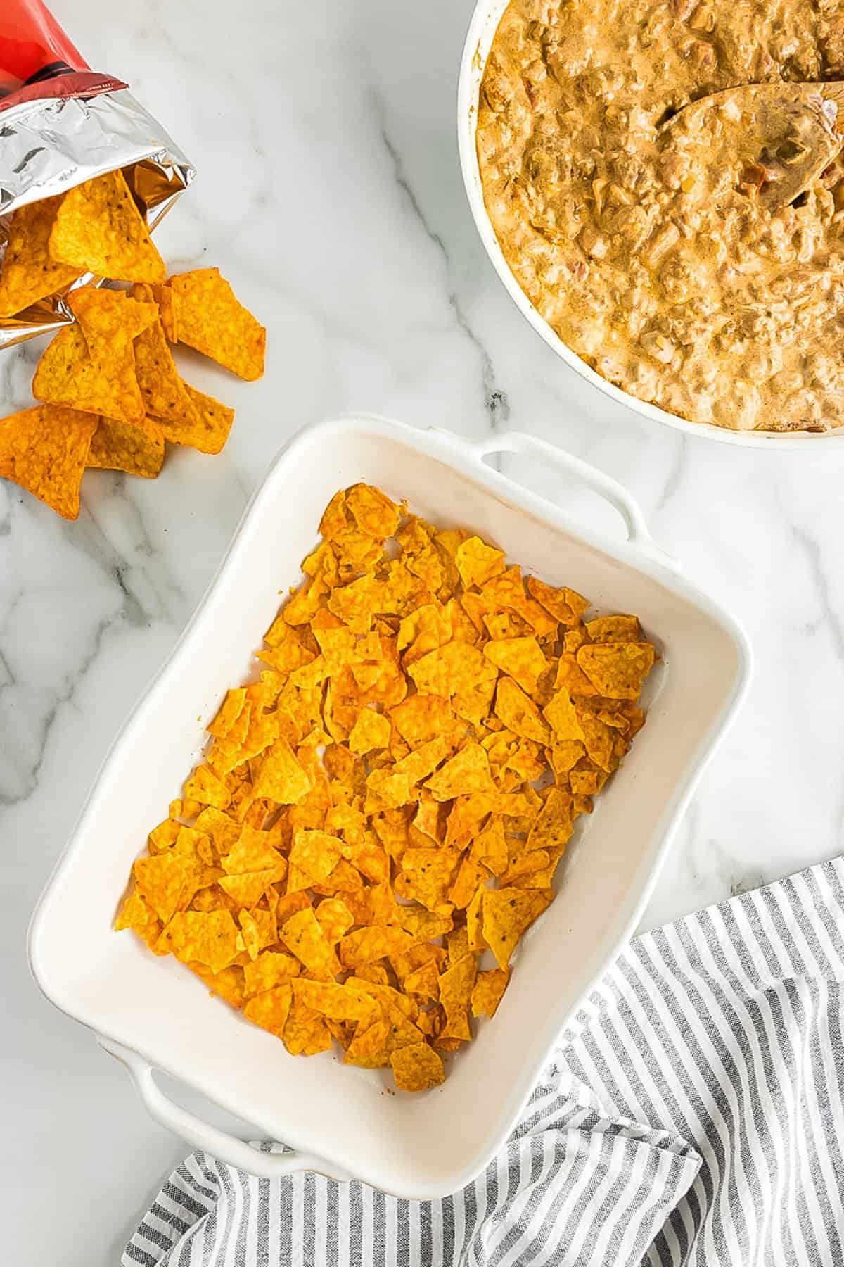 White casserole dish with crushed cheese Doritos