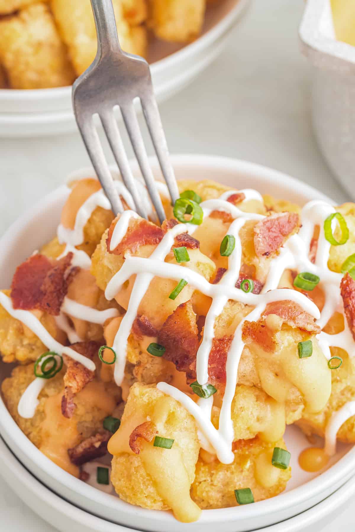 Fork taking a bite out of loaded tater tots