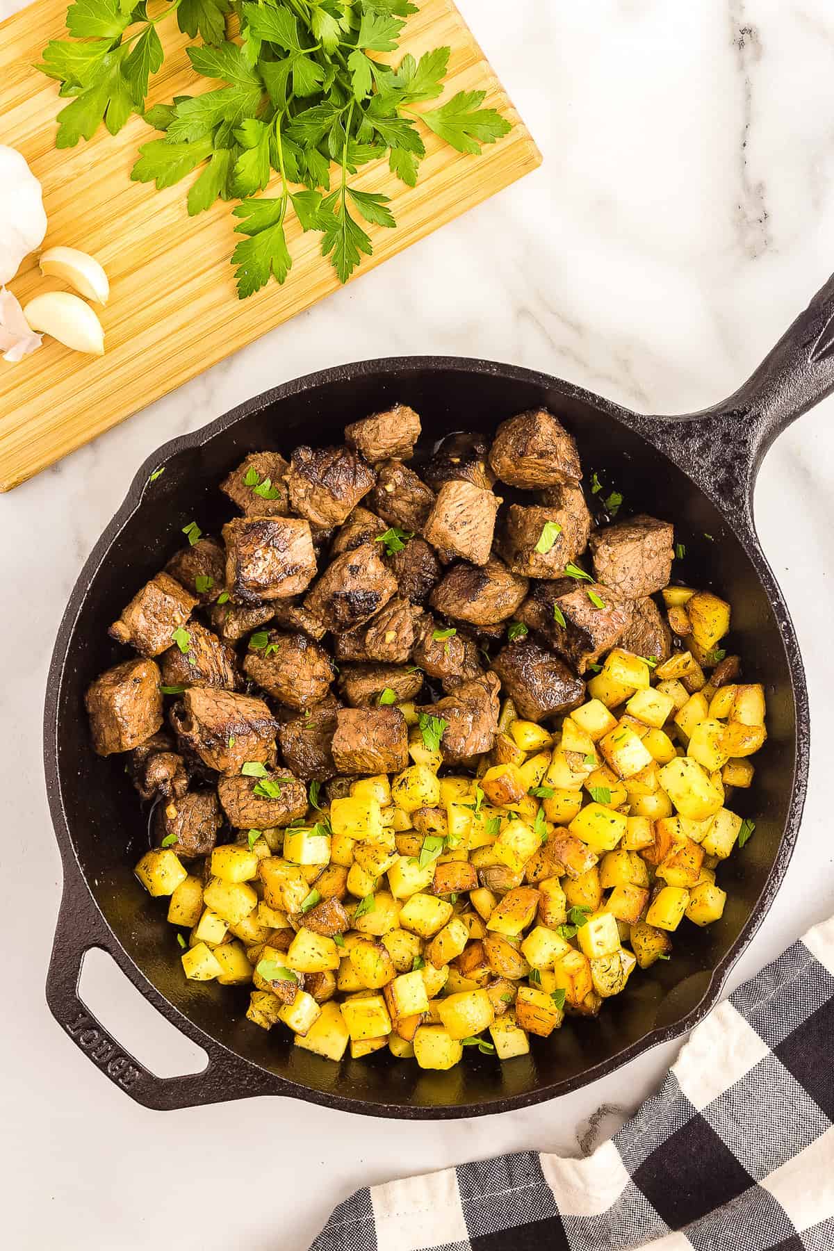 Cast iron pan with steak bites and potatoes