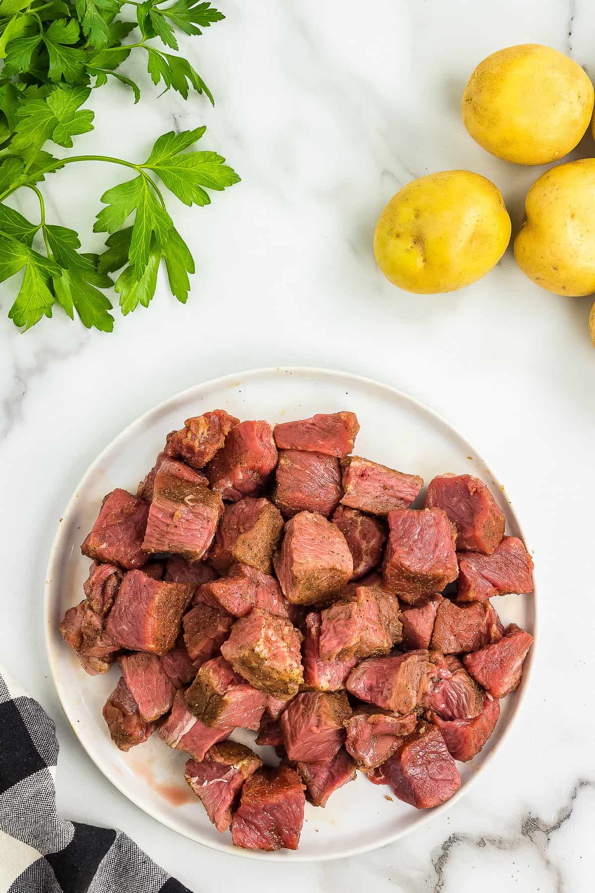 Glass bowl of pieces of steak with rub