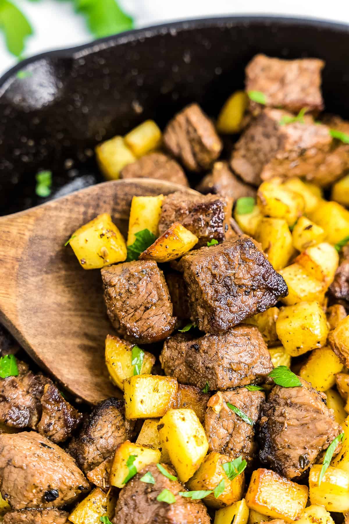 Wooden spoon with steak and potatoes