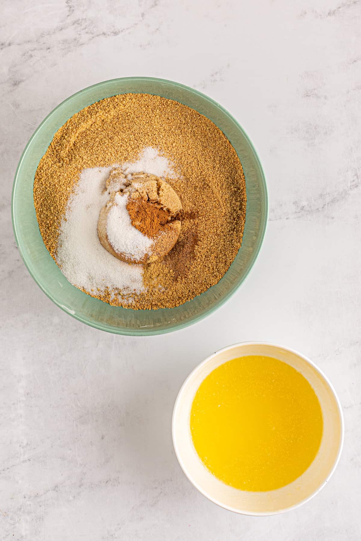 Mixing bowl with graham cracker crumbs, brown sugar, sugar, cinnamon, nutmeg and ginger