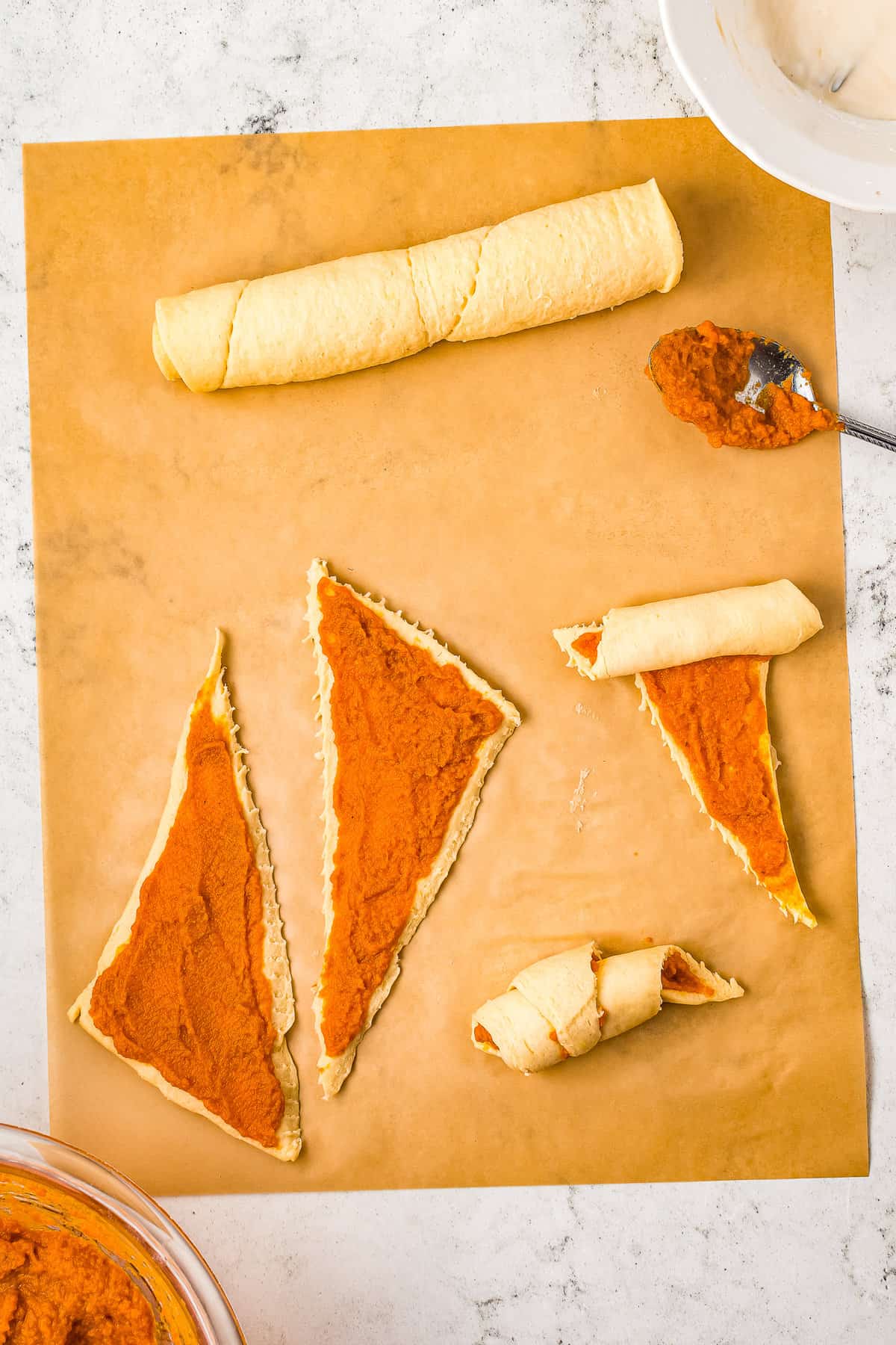 Rolling up crescent rolls with pumpkin filling