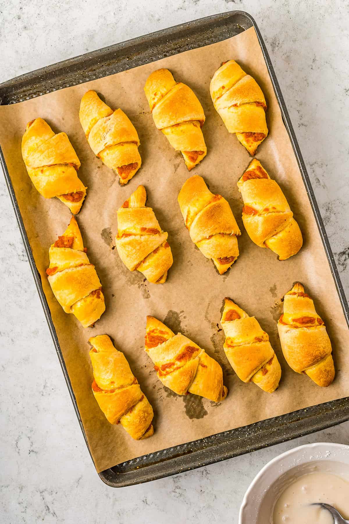 Overhead image of pumpkin pie crescent rolls on sheet pan