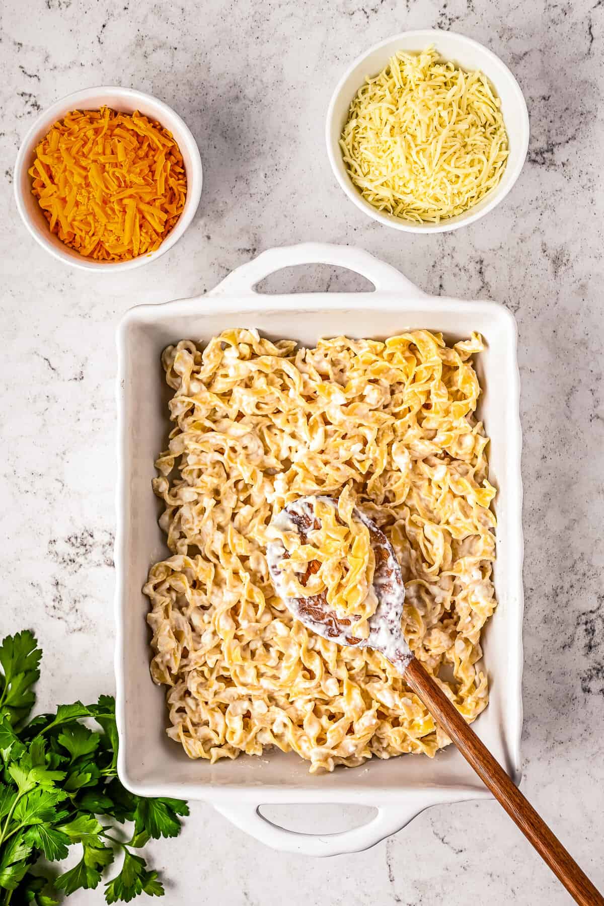 White baking dish with cheesy egg noodles layers