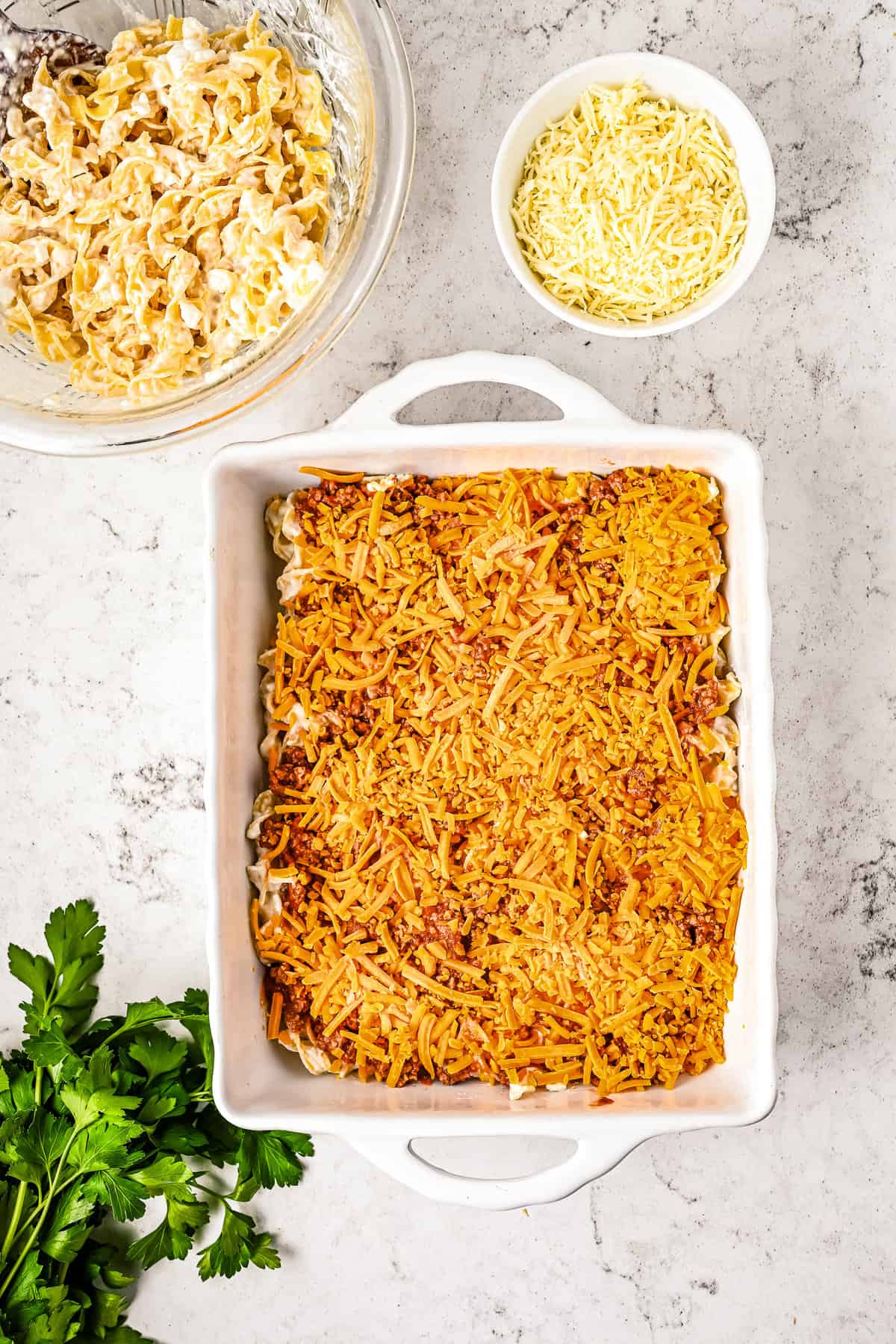 White baking dish with cheddar cheese on casserole