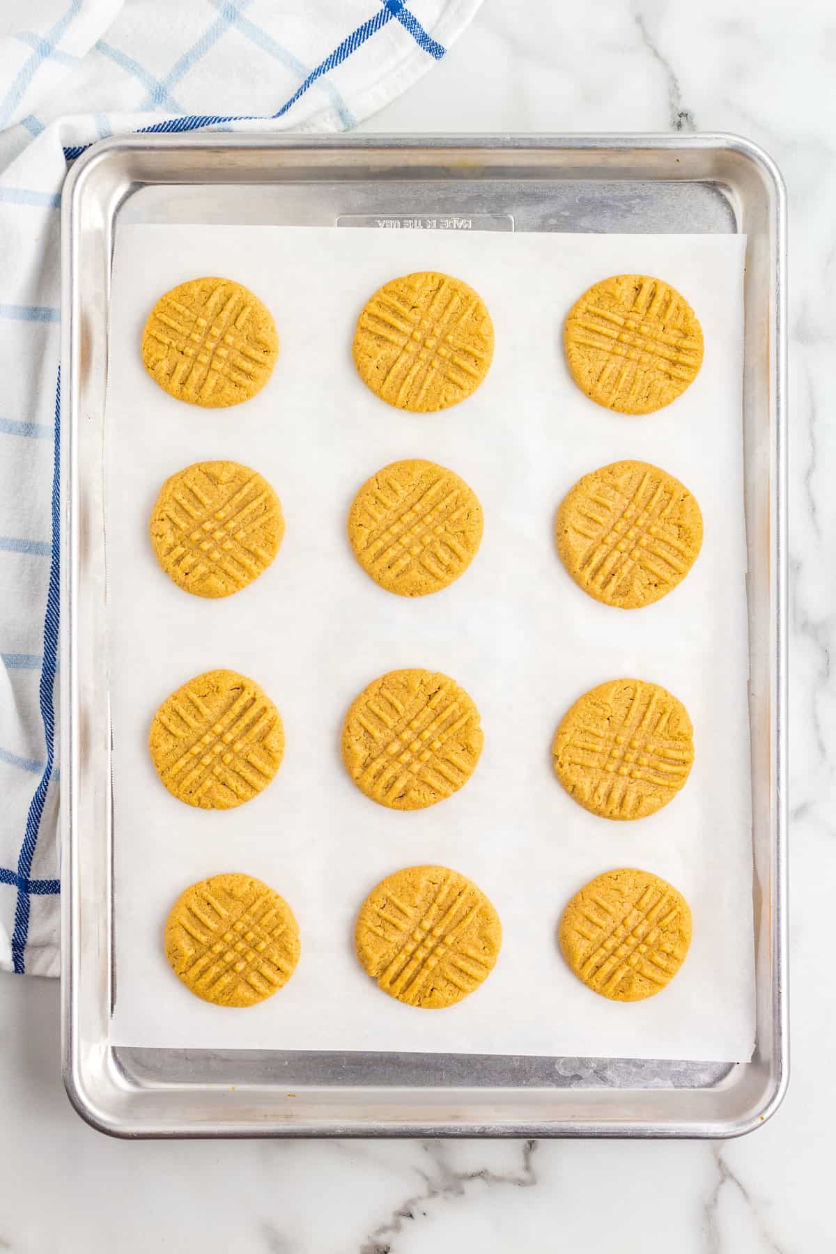 Baked criss crossed peanut butter cookies on sheet pan