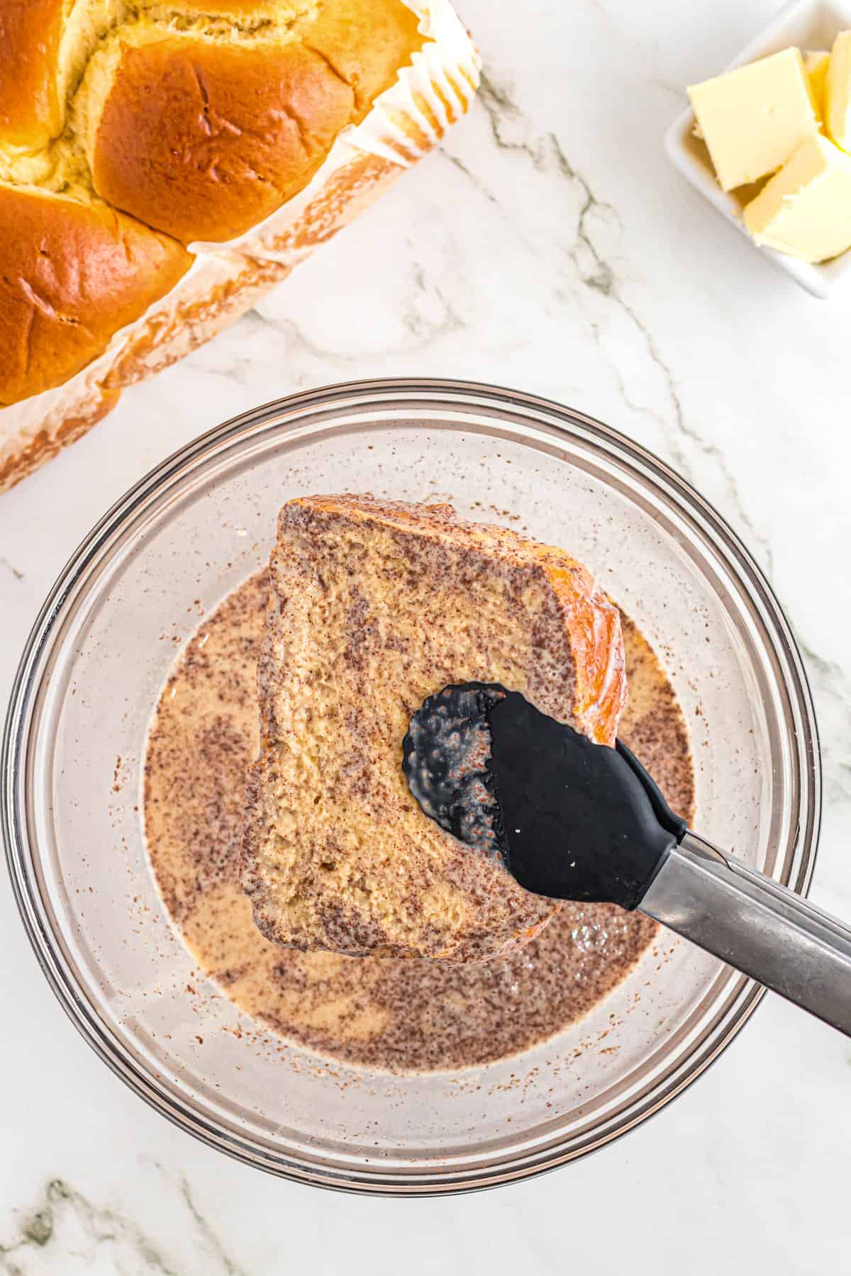 Taking piece of bread out of custard mixture