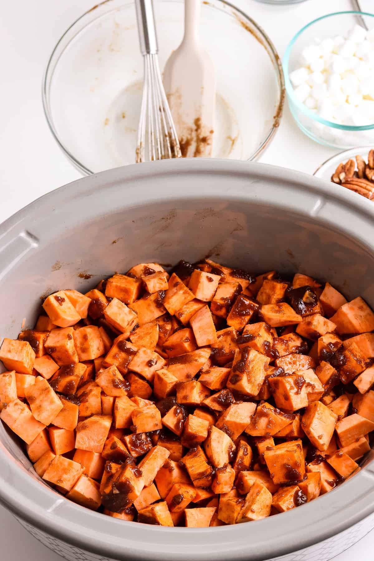 Crock pot with diced sweet potatoes tossed in brown sugar butter