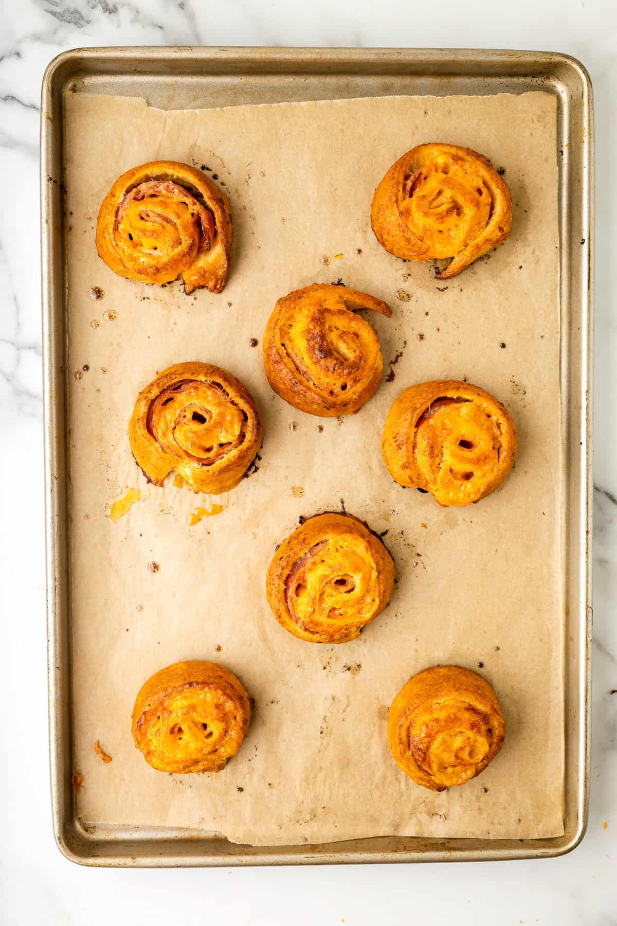 Overhead picture of sheet pan with baked ham and cheese pinwheels