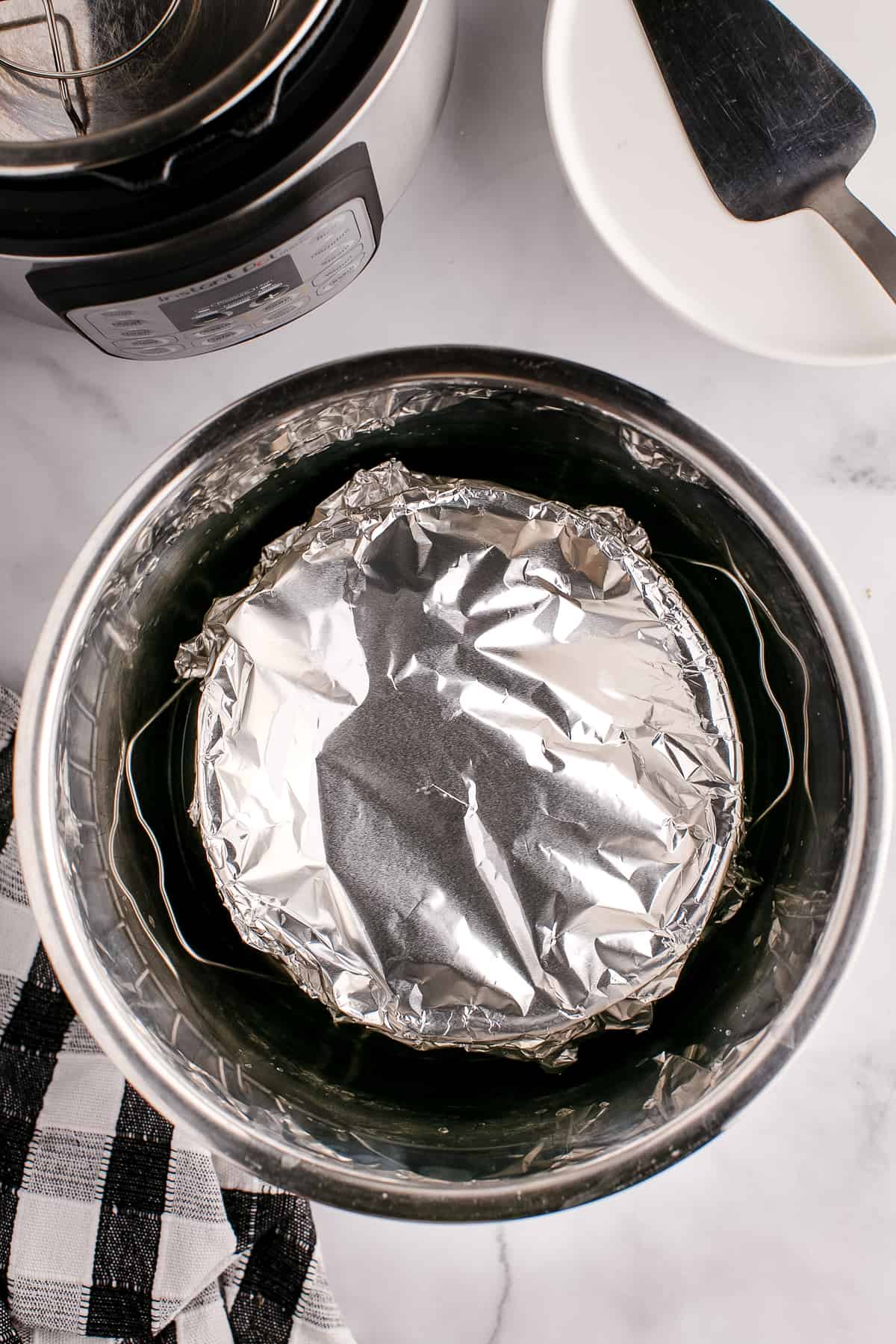 Cheesecake covered in aluminum foil in Instant Pot