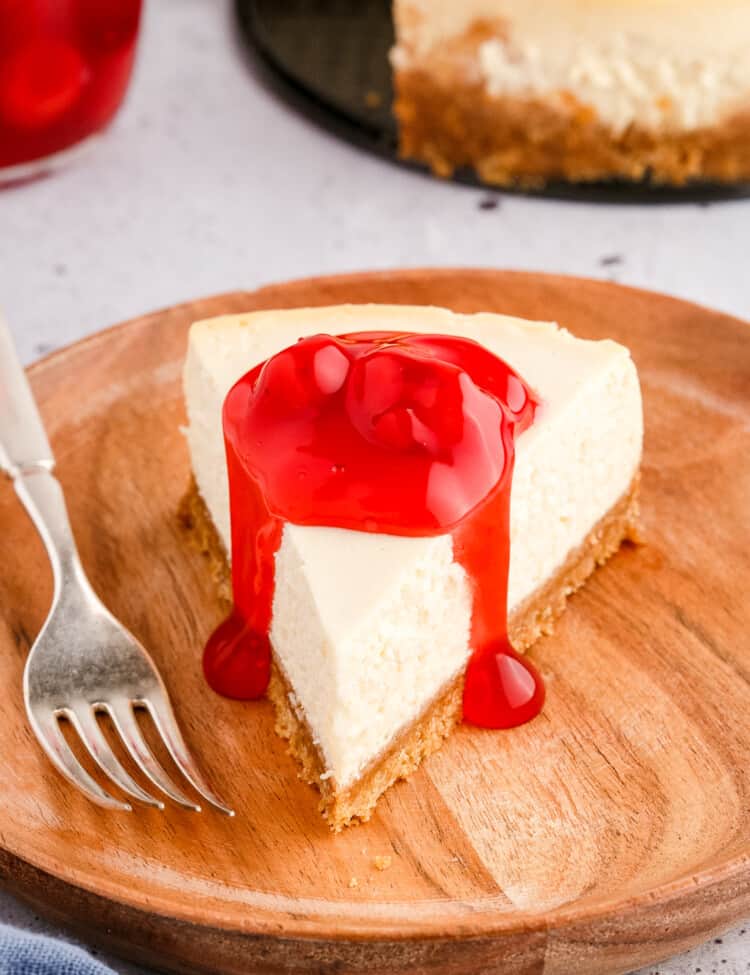 Slice of cheesecake topped with cherry pie filling