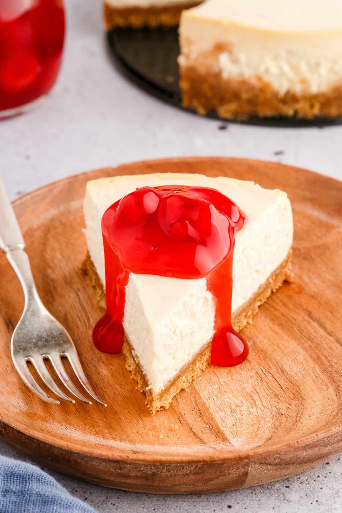 Slice of cheesecake topped with cherry pie filling