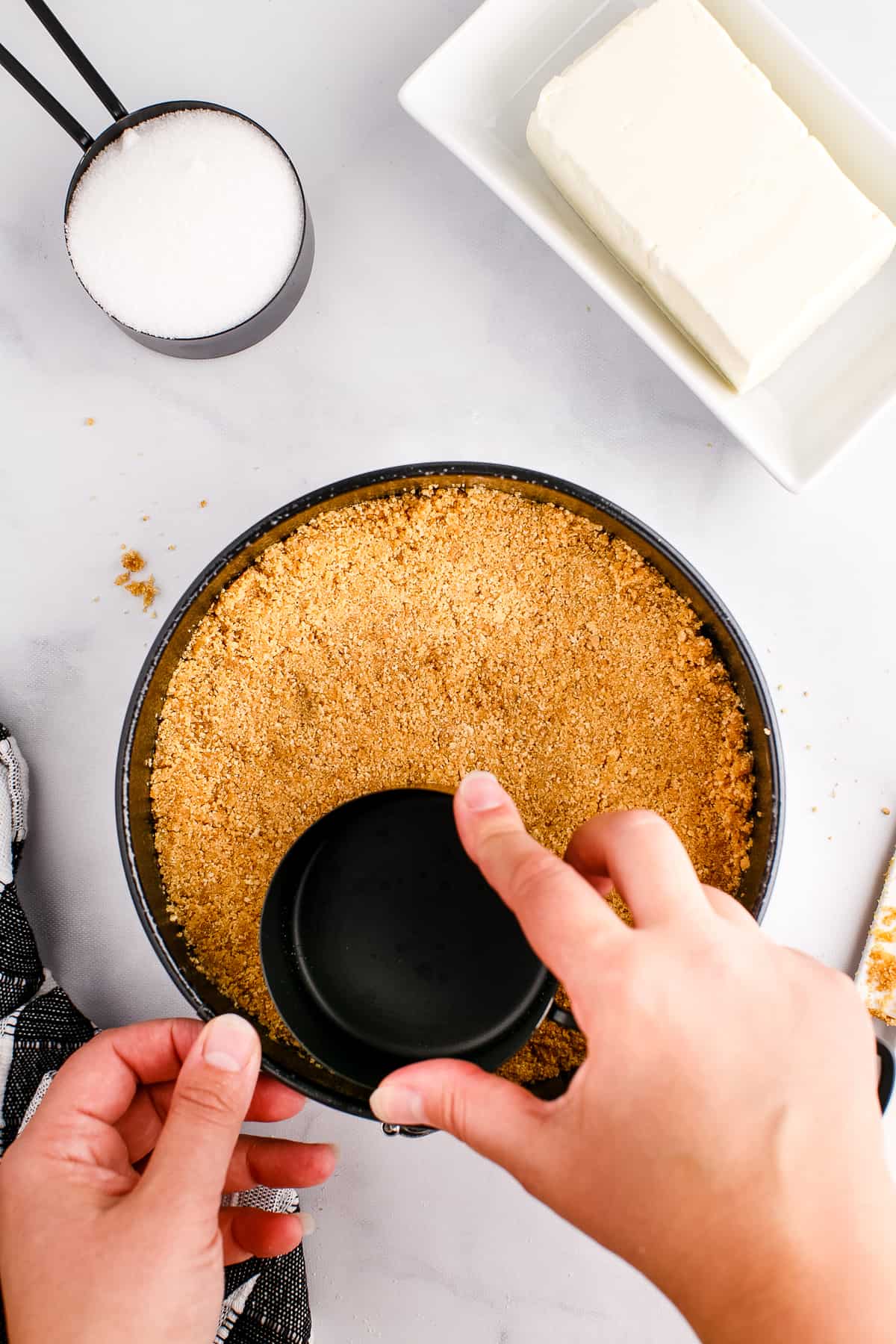 Pressing graham cracker crust into springform pan